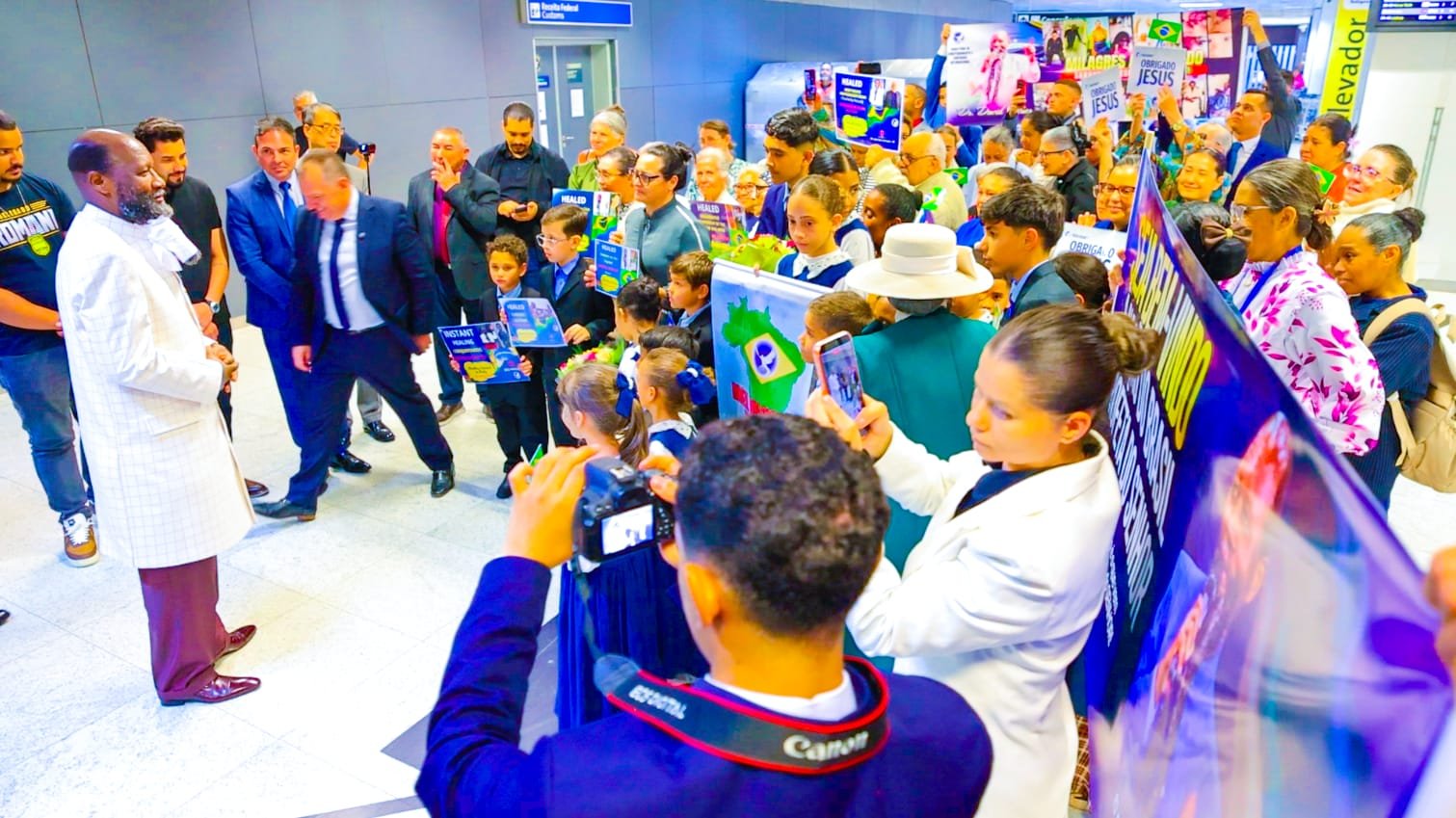 Believers gathered at São Paulo airport holding flags and healing testimonies to receive Prophet Dr. David Owuor